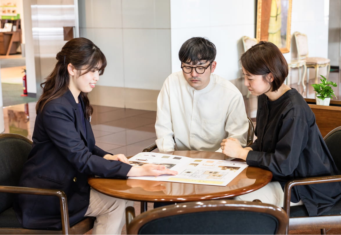 ショールームでスタッフが来店客に説明をしている様子